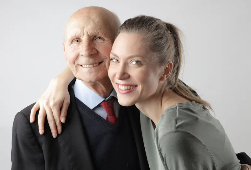 A daughter with her arm around her smiling father