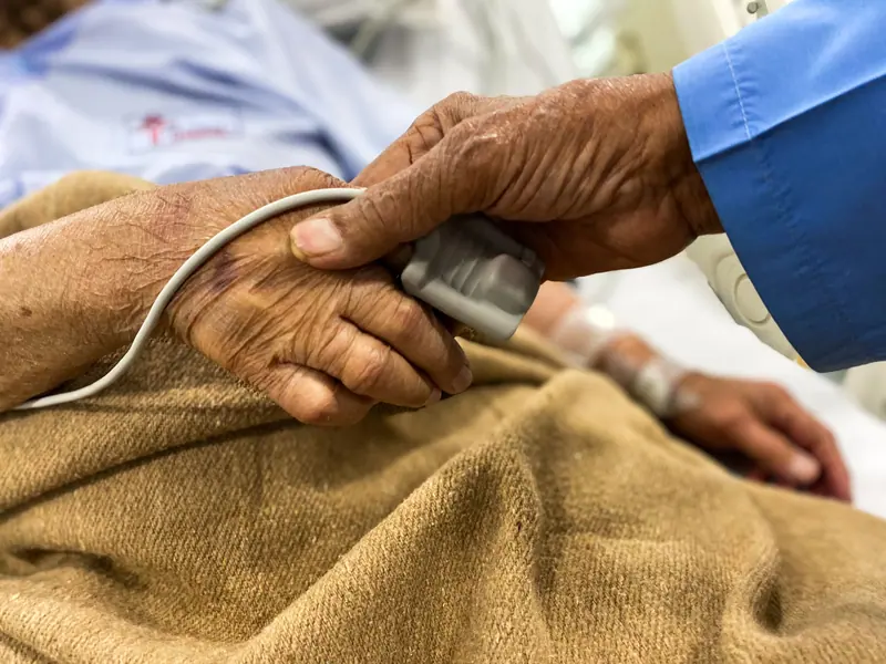 A doctor's hand comforting a patient's