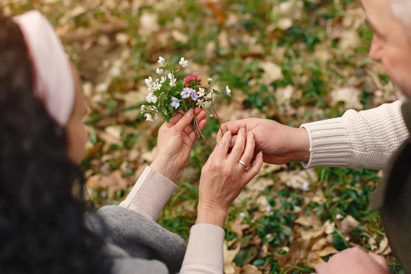 A couple's hands gathering wildflowers