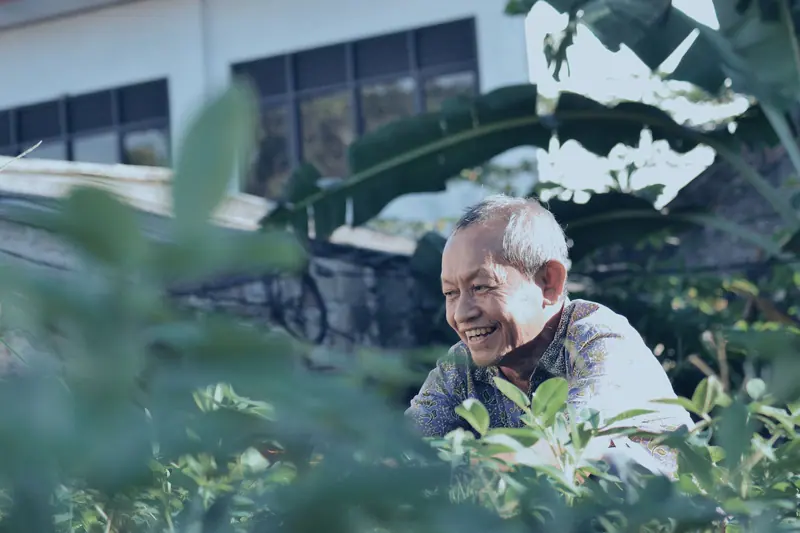 A patient smiling among his garden plants