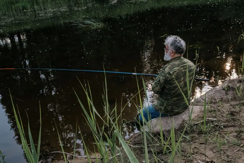 A man fishing at the water's edge