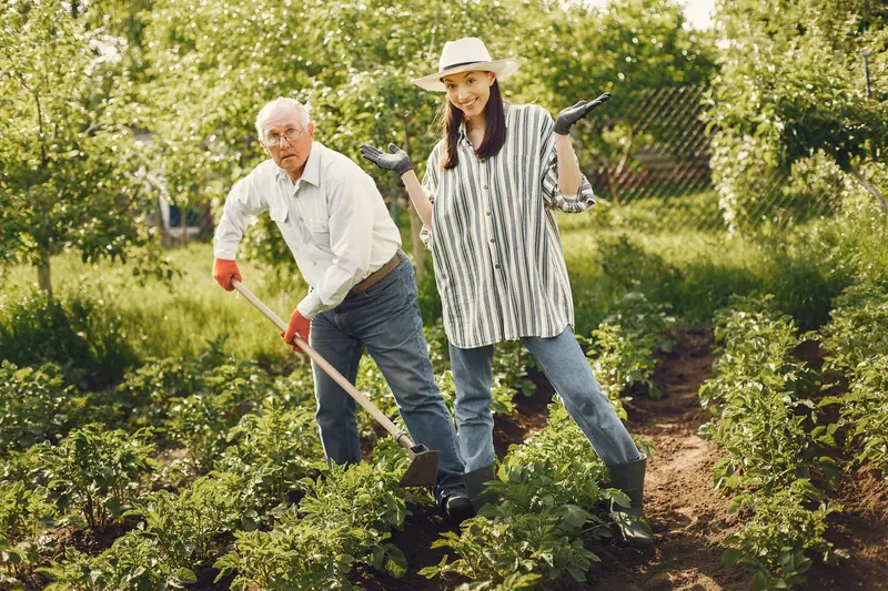 A patient and his granddaughter working the garden together