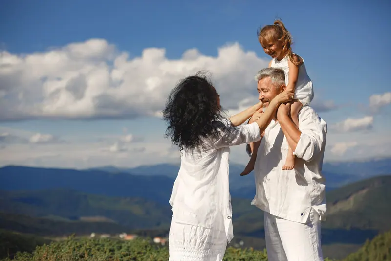 Grandparents playing with their granddaughter outdoors