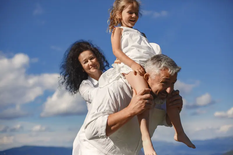 A grandfather giving his granddaughter a shoulder ride