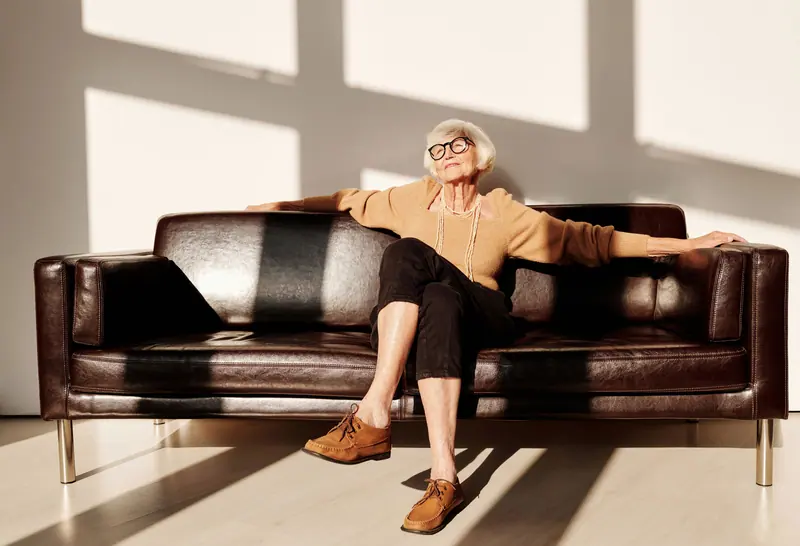 A patient relaxing on a leather sofa in a sunny room
