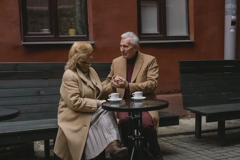 A married couple sharing coffee at an outdoor table