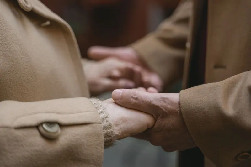 Two hands held together at a winter coat sleeve