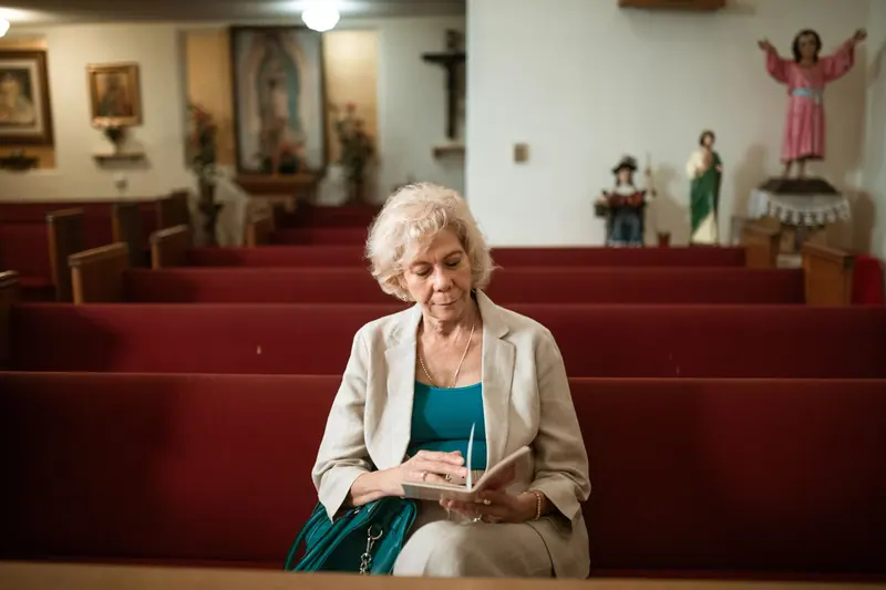 A woman reading her Bible in the quiet of an empty church