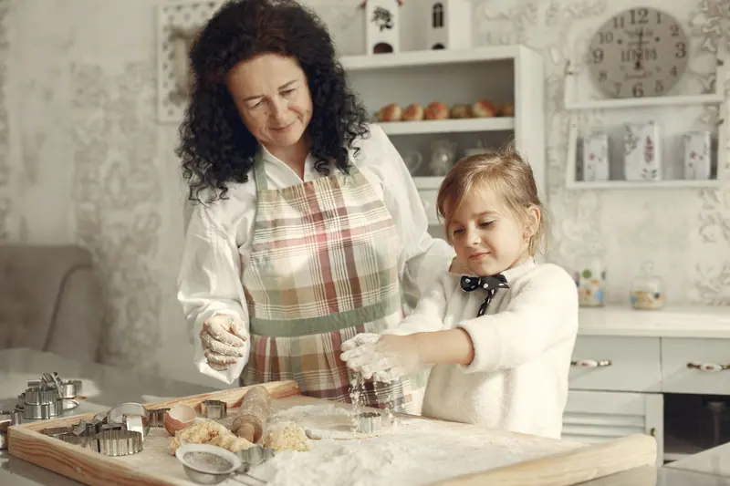 A grandmother and granddaughter baking together