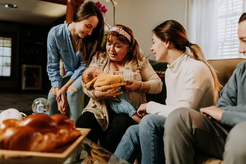 A grandmother holding the newest baby surrounded by family