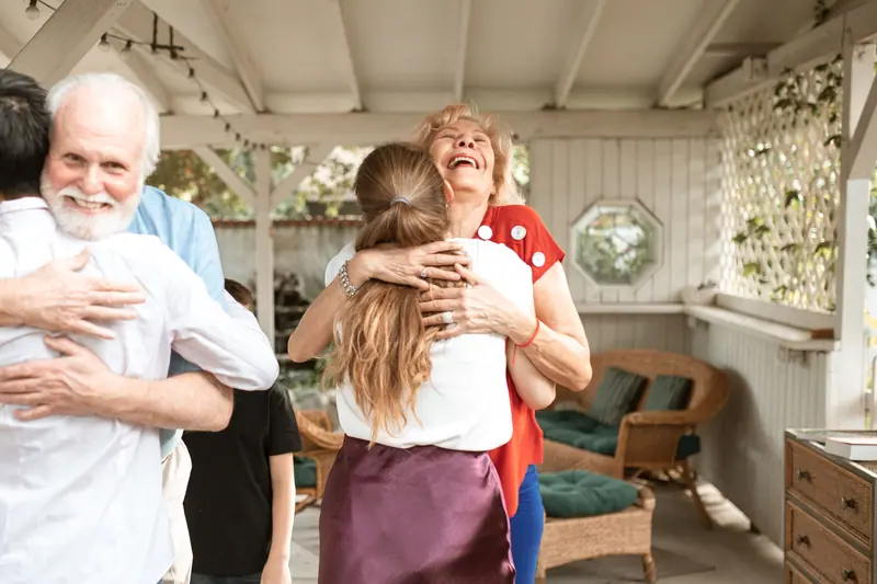 A grandfather hugging his granddaughter at a backyard visit