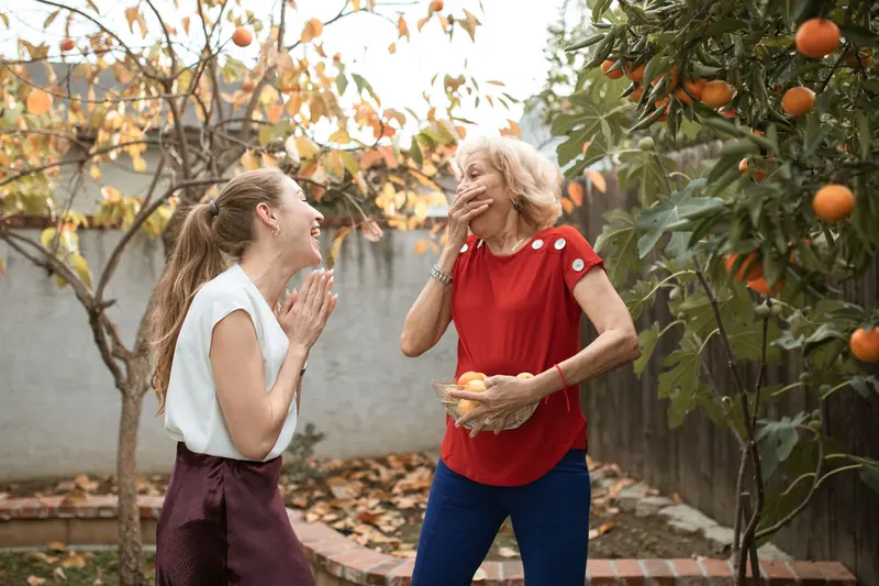 A daughter surprising her mother with a hug in the garden
