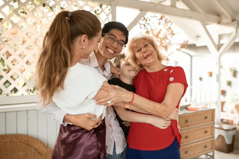 A family hugging hello on the covered back patio
