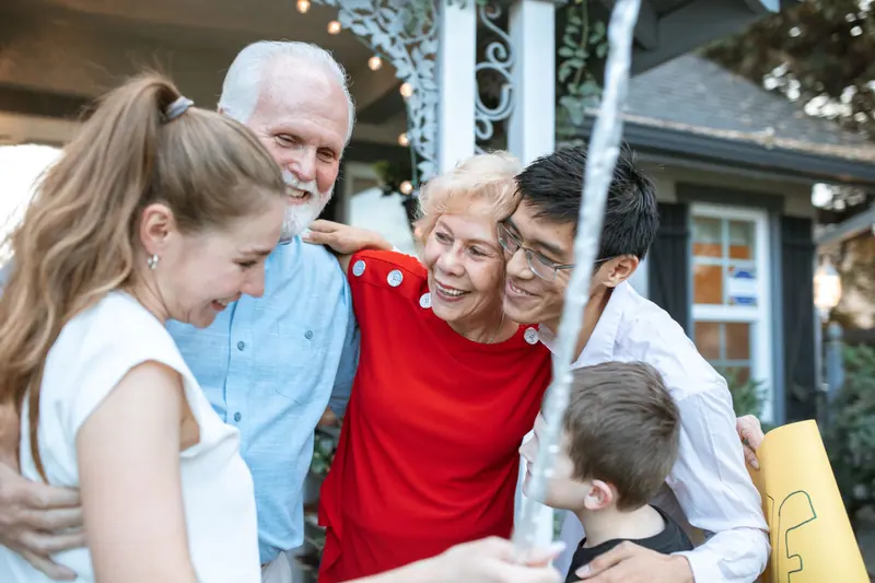 Three generations of a family embracing in the backyard