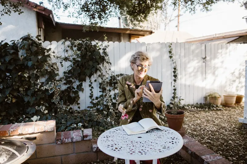 A woman on her tablet in the garden