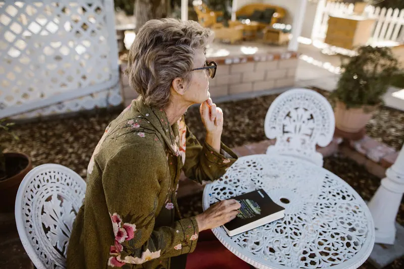 A woman writing in her journal at the garden table