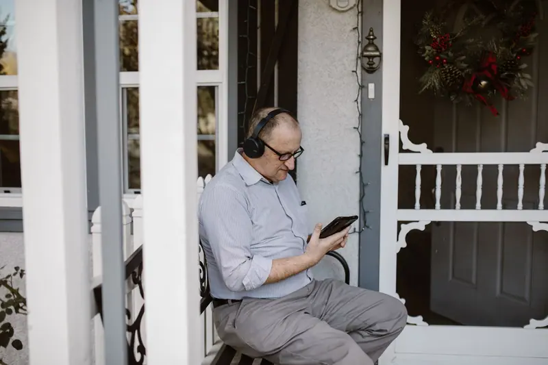 A man listening to music on his porch