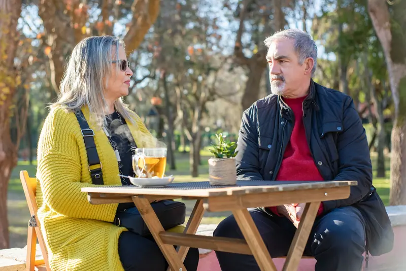 A couple talking over tea in the park