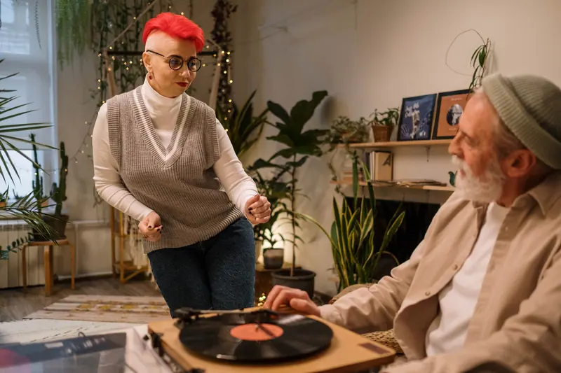 A woman putting a favorite record on for her husband