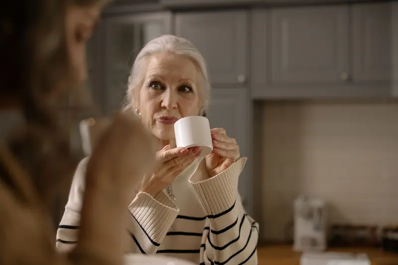 A woman with her cup in the kitchen