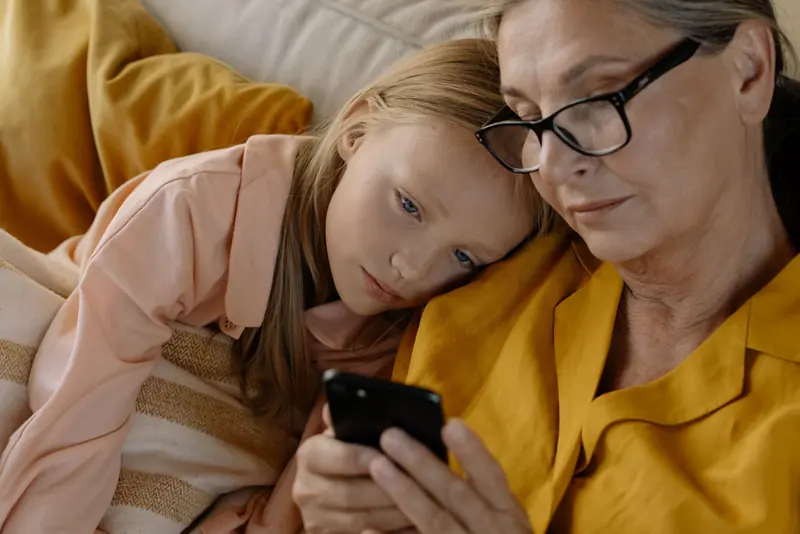 A grandmother and granddaughter looking at photos