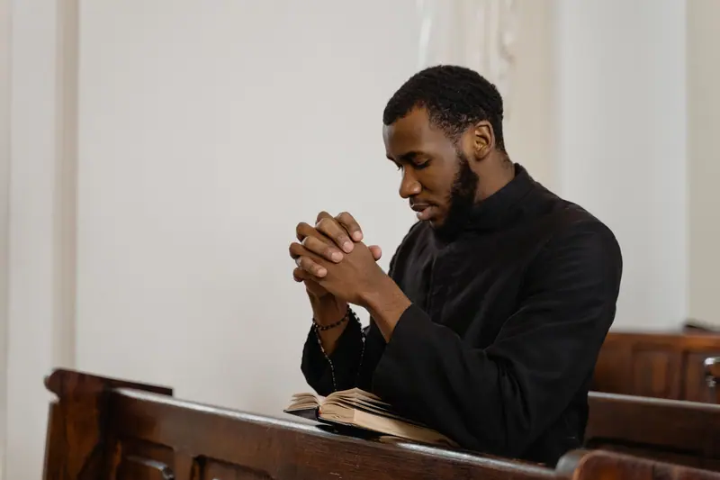 A chaplain in prayer in a quiet chapel