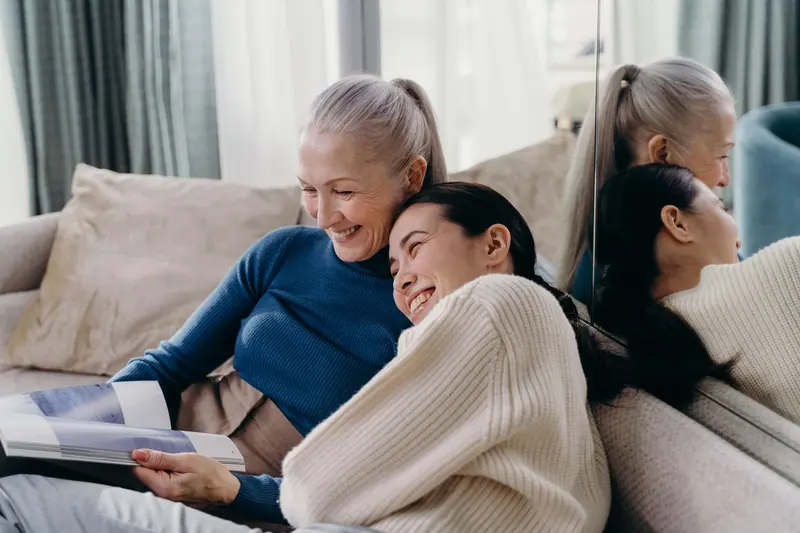 Three generations of women laughing on the couch