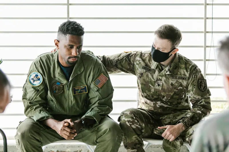 Veterans sitting together, one with a hand on the other's shoulder