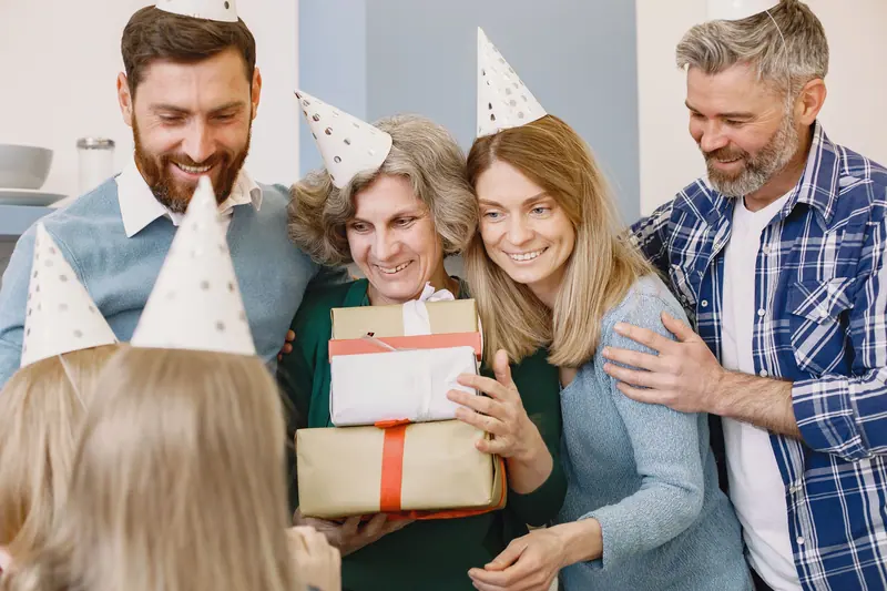 A grandmother opening gifts with her family