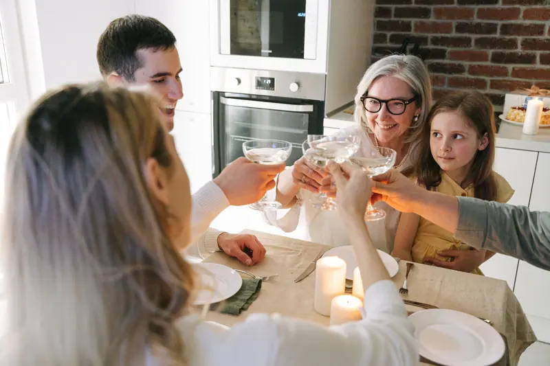 A family raising glasses around the dining table