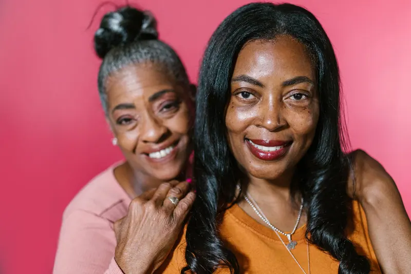 A mother and daughter hugging, faces close