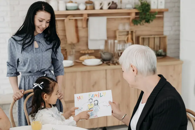 A granddaughter showing her grandmother a drawing