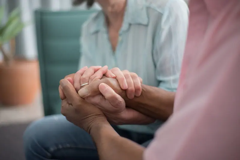 A married couple's hands folded together