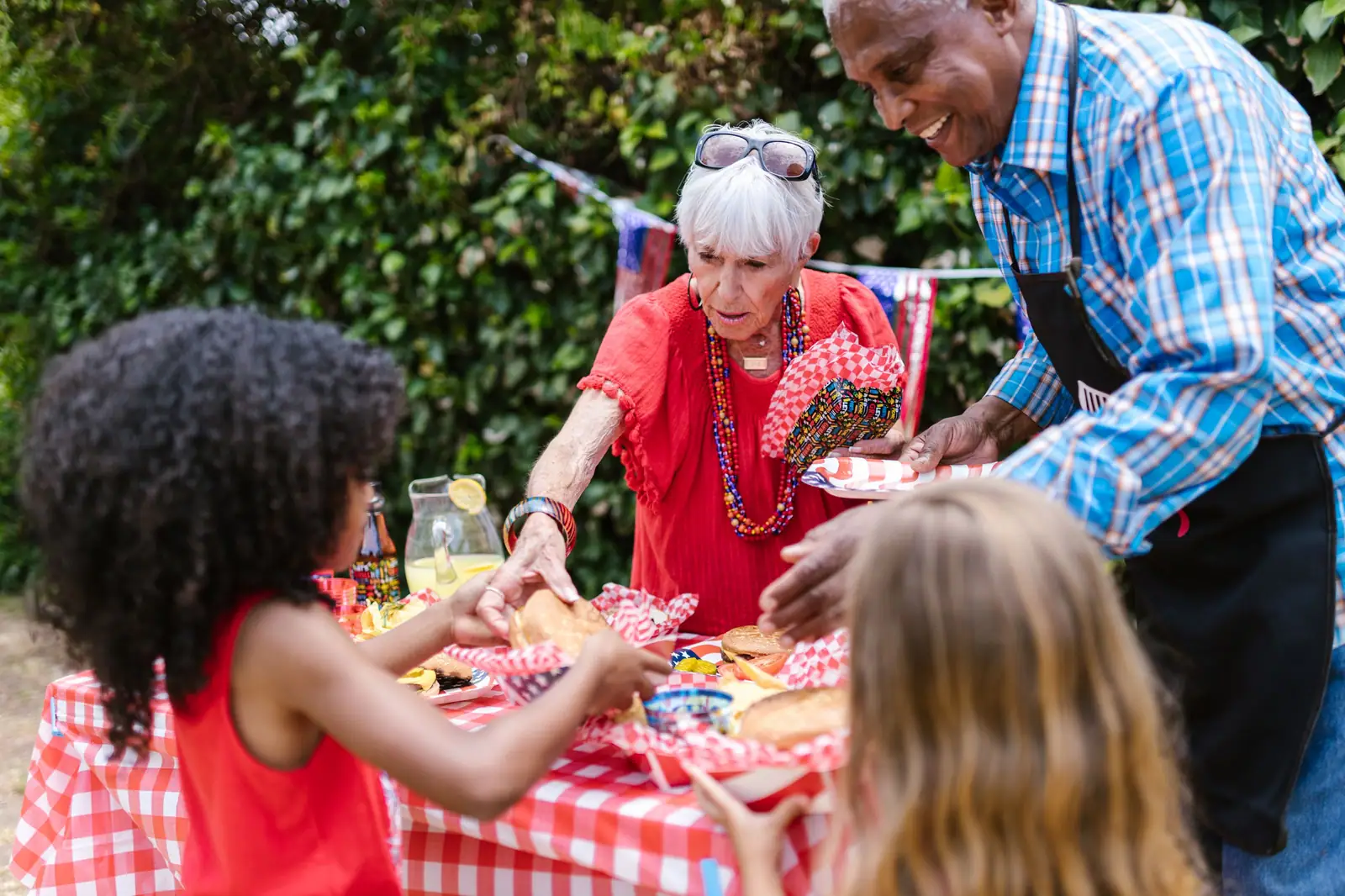 Grandparents serving food at a backyard family party