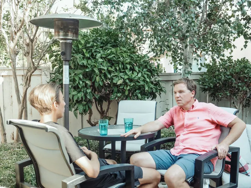 A father talking with his teenage son outside