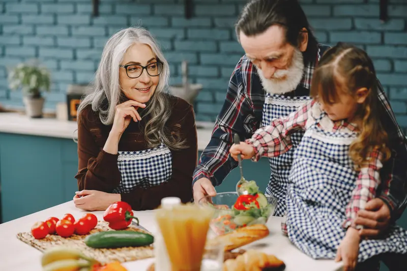 Grandparents cooking with their granddaughter