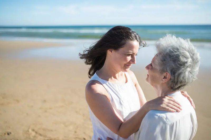 A daughter hugging her mother at the shore