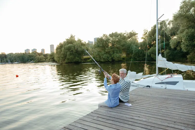 A grandfather and grandson fishing off the dock
