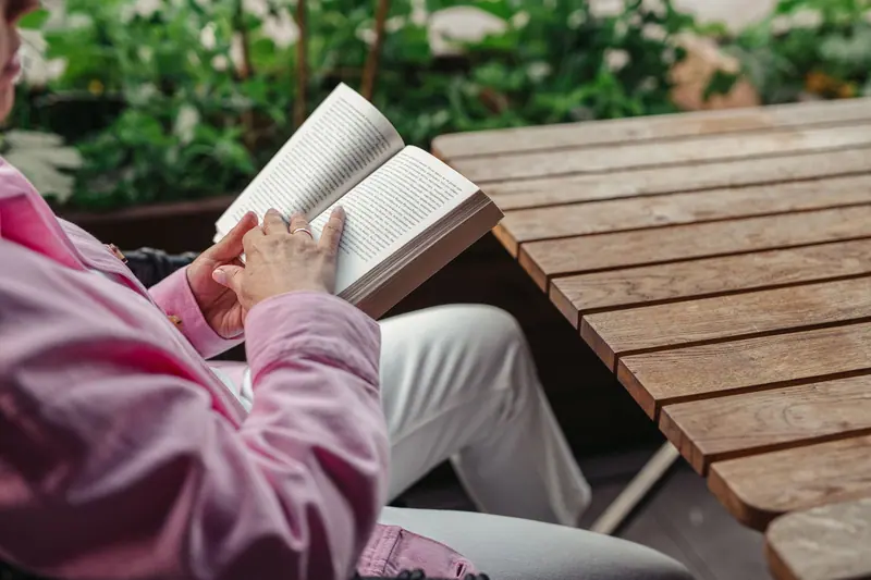 A woman reading at a garden table