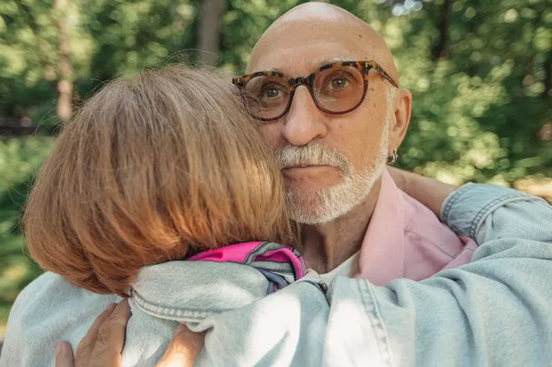 A daughter holding her father close in the afternoon sun