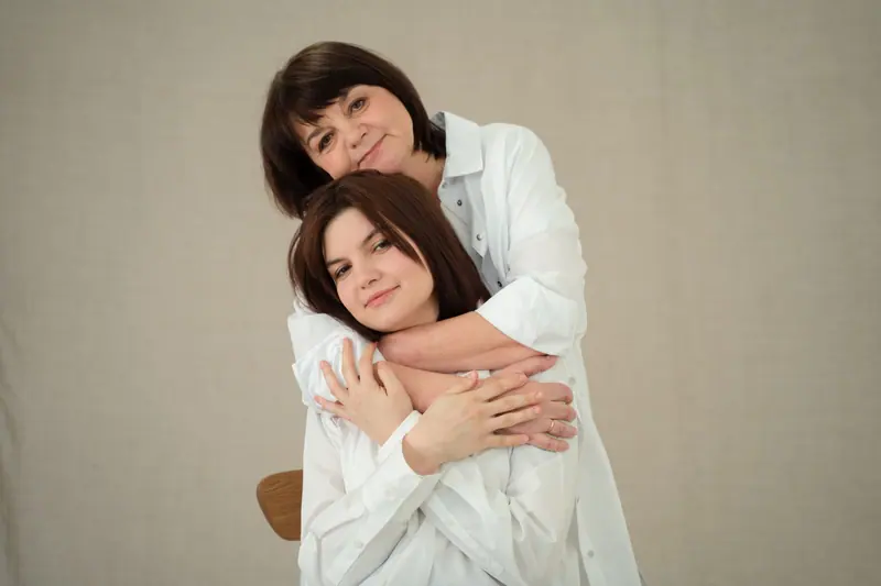 A mother and grown daughter in a warm embrace