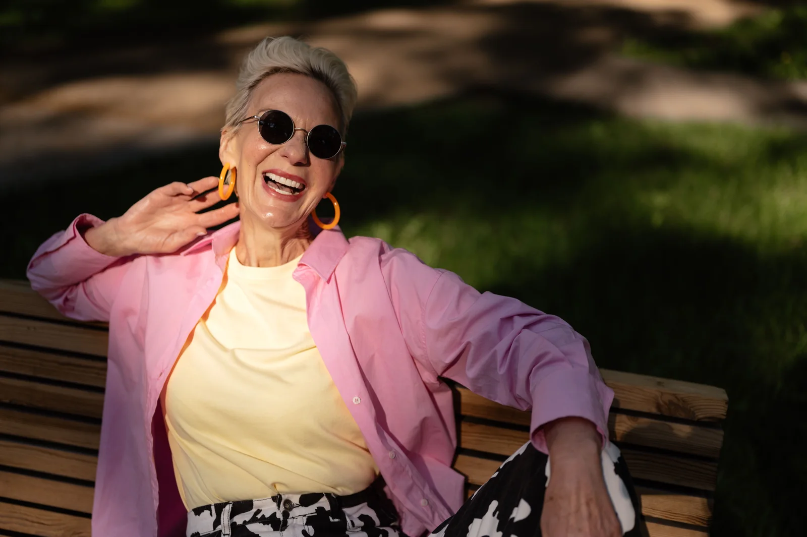 A stylish older woman laughing in the sunshine