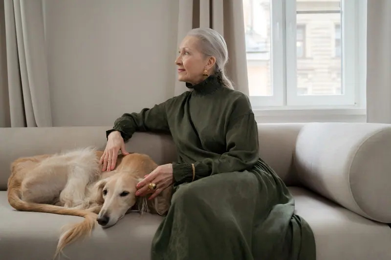 A resident relaxing on the sofa with the cottage dog at her feet
