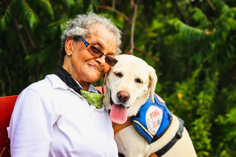 A resident and the visiting therapy Lab, cheek to cheek