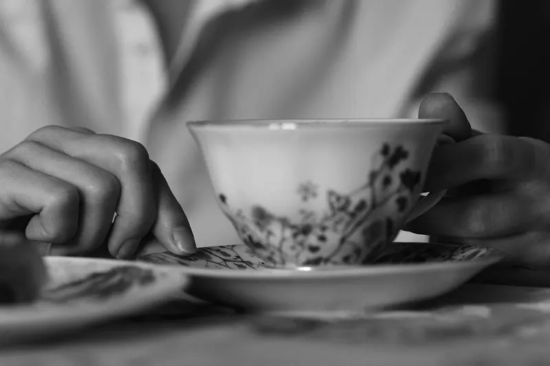 A teacup and saucer in a resident's hands