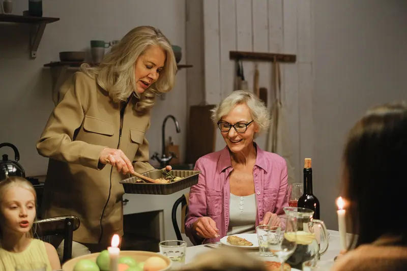 A resident smiling at the head of the table