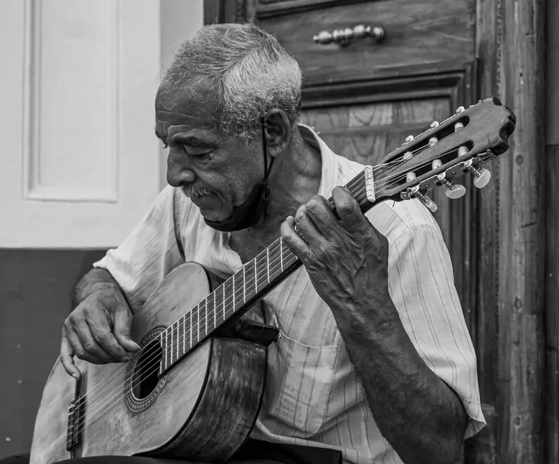Black-and-white photograph of a resident playing classical guitar