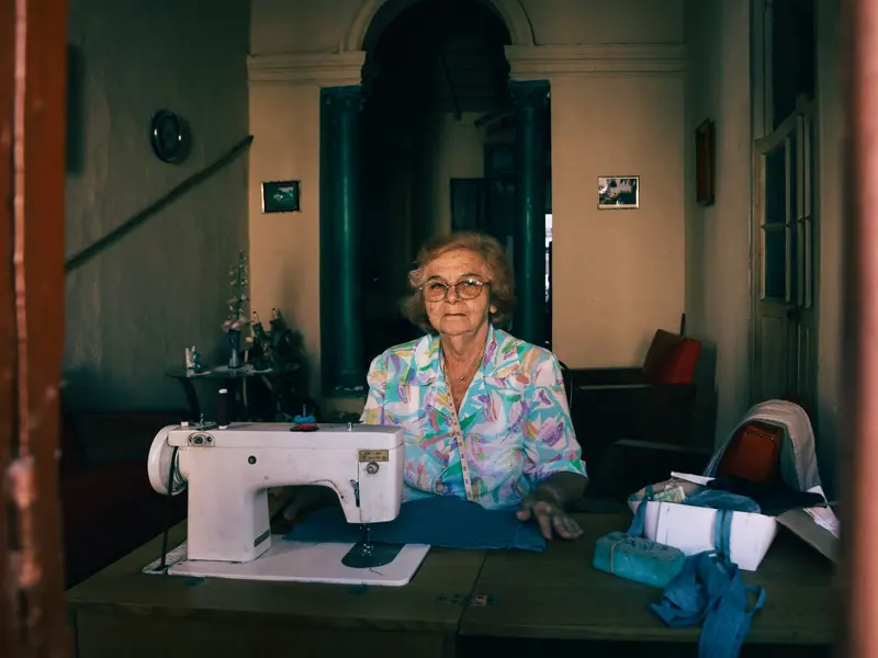A resident at her sewing machine by the window