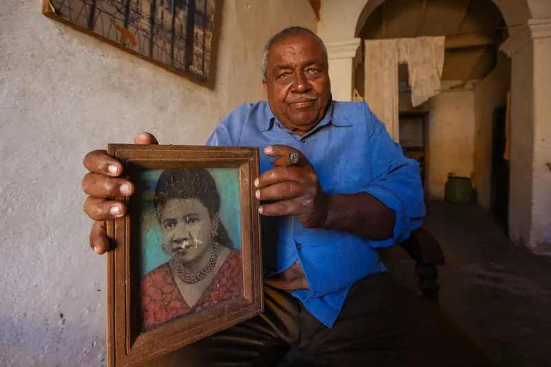 A resident holding up a painted portrait of his mother