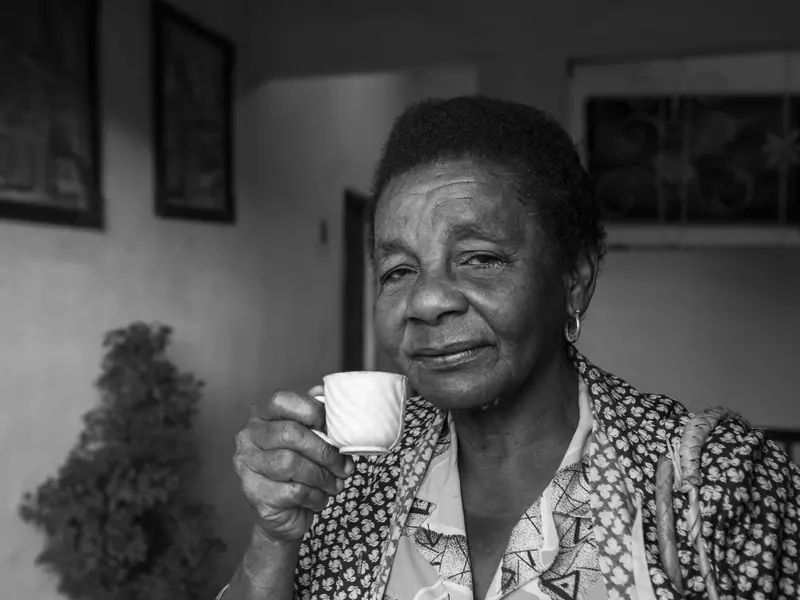 Black-and-white portrait of a resident with her coffee cup